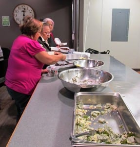 KIC elders box up leftovers from a recent traditional-food lunch, to take home for dinner.