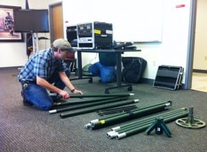 Kevin Hurtley assembles part of the portable transmission tower for the new emergency broadcast studio.