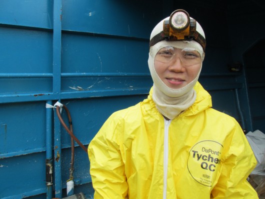 Cat wears a Tyvek suit while cleaning out a fuel tank on a crab boat.