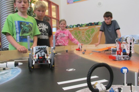 Campers watch as one team's EV3 robot rolls toward its mission.