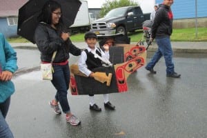 A boy dressed as a Tsimshian pioneer in a canoe.
