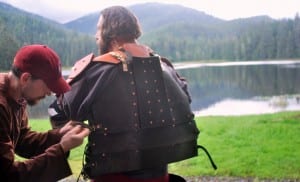 Jake Phelps helps Dustin Shull put on his armor.