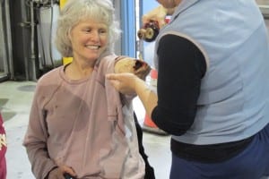 A cheerful volunteer victim gets a face amputated arm wound applied before the drill.