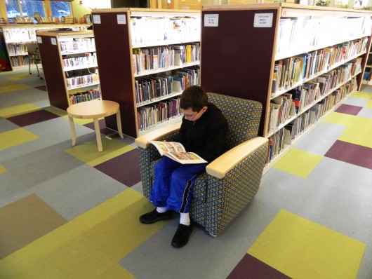 A young patron reads a book at the Ketchikan Public Library.