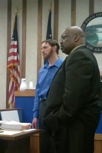 John Mathis Jr. (Left) and his lawyer, Rex Butler, stand in Ketchikan Superior Court to view video of the two runaway boys boarding a ferry headed to Washington, where the boys were later apprehended. (Photo by Madelyn Beck)