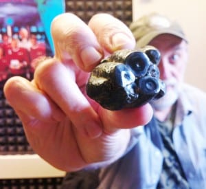 Ketchikan artist Ray Troll holds up a Desmostylus tooth. (Photo by Leila Kheiry)