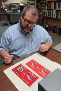 Researcher Ross Coen views some of the labels in the museum's collection.