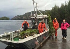 Shoal Cove is accessed from Ketchikan by boat or float plane. Art Williams (boat operator), Aaron Steuerwald (forester), Steve Hollis (seasonal forestry technician), and Crystal Vieira (seasonal forestry technician) loaded the trees. (USFS photo)