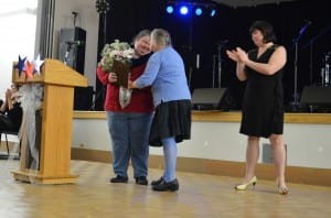 Kelly Johnson receives flowers along with her award for outstanding youth leader.