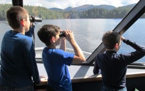 Three students look for whales during a recent fourth-grade field trip to Carroll Inlet. (Photo by Leila Kheiry)