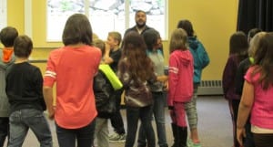 Students practice walking to a drum beat and freezing when the drum stops.
