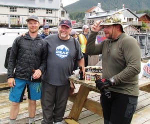 Mike Firari, Charlie Starr and Tom Logan enjoy a beer after finishing the second annual Race to Alaska. (Photo by Leila Kheiry)