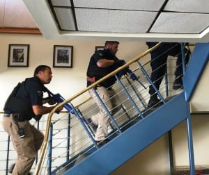 Ketchikan Police Department officers head upstairs to capture the bad guy during an active shooter drill at the local Coast Guard base. (Photo by Leila Kheiry)