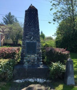 A memorial to Metlakatla's pioneers stands outside William Duncan's cottage in the town's historic neighborhood. (Photo by Leila Kheiry)