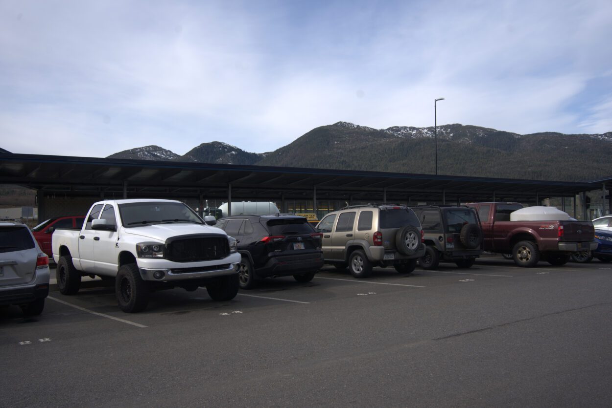 a row of parked cars with mountains in the background